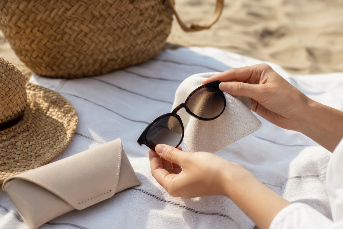 Napszemüveg tisztítása mikroszálas kendővel nyári strandon